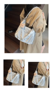 Detail of silver metallic tote bag featuring pleated texture and cute teddy bear charm