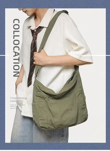 Model wearing large olive green canvas shoulder bag with multi-pocket utility design