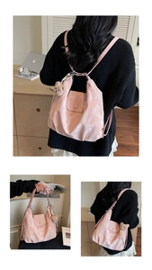 Detail of pink convertible tote bag showing textured surface and cute brown teddy bear charm