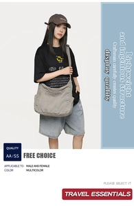 Detail view of large grey canvas crossbody bucket bag with side pockets and wide strap