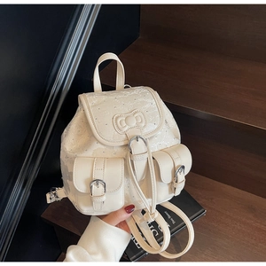 Close-up of cream mini backpack featuring chic jacquard patterns and cute bow detail