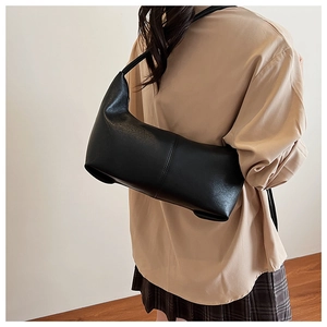 Close-up of minimalist black matte underarm bag with vertical stitching detail