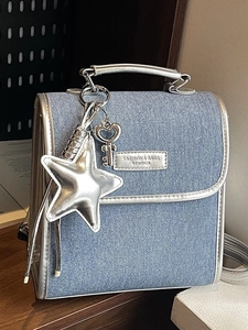 Denim blue backpack with silver star pendant and polished hardware in high design style