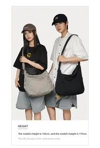 Large canvas messenger bags on models showing size comparison and crossbody drape