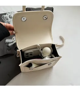 Vista dall'alto dell'interno spazioso della borsa beige con telefono e ombrello mini