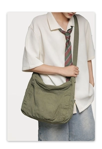 Olive green large canvas crossbody bucket bag with multi-pocket utility design