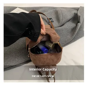 Internal capacity of brown suede mini backpack showing storage of cosmetics