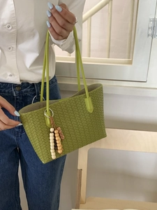 Grass green woven tote bag with beaded tassel charm and minimalist top handles for women