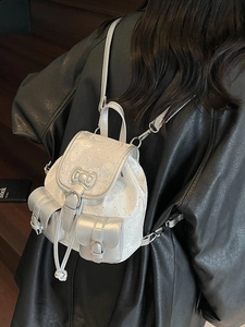Silver mini backpack with white floral embroidery and a bow buckle on the flap cover