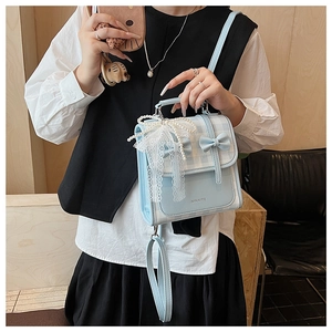 Détail du sac à main à carreaux bleu clair avec nœuds et pendentif perlé