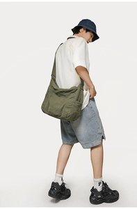 Detail of adjustable strap and side pocket on the olive green canvas bucket bag