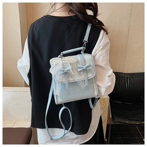 Détail du sac à dos bleu clair avec nœud en dentelle et lettrage Ninaite sur le rabat
