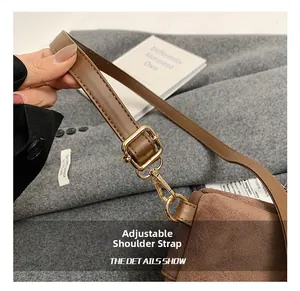 Detail showing adjustable shoulder strap with gold metal buckles on brown suede backpack