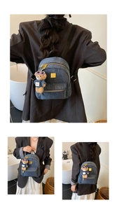 Tre viste di uno zaino in denim con placca dorata e ciondolo orsetto di peluche