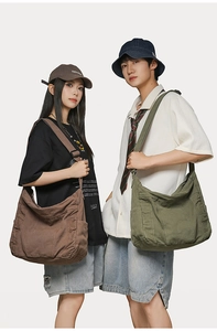 Detail of canvas crossbody bucket bags with wide straps in brown and olive green