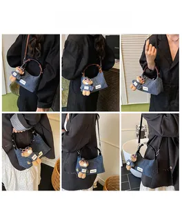 Hobo-Tasche aus Denim mit Bärenanhänger und zwei Riemen am Model für vielseitigen Stil
