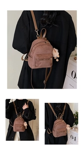Detailed view of mini brown matte backpack with gold zippers and beige fur ball pendant
