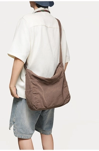 Side view of deep brown large canvas bucket bag with side pocket on female model