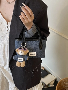 Blue textured bucket bag with black leather handle and cute teddy bear charm