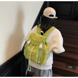 Detailed back view of a large grass green nylon travel backpack with white buckle closure