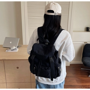 Détail du sac à dos en nylon noir imperméable montrant la boucle et le rabat de fermeture
