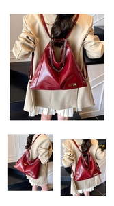 Detail of vintage burgundy patent leather backpack with silver chain and heart charm