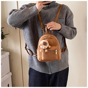 Detail of brown suede mini backpack with gold zippers and cute alpaca plush keychain