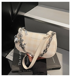 Détail du sac à carreaux crème avec chaîne argentée et charmant pendentif chien ballon