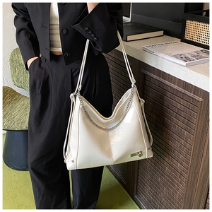 Detail view of cream white shoulder bag with shiny oil wax leather and silver chain