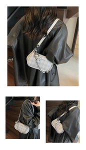 Détail du sac bandoulière en toile à carreaux gris avec chaîne et breloque ours