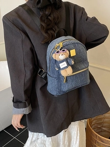 Zaino in denim blu con ciondolo a forma di orsetto e design moderno minimalista