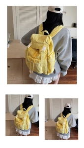 Détail du sac à dos jaune clair avec boucle et cordon sur tissu en nylon plissé élégant