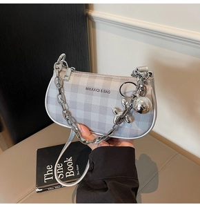 Détail du sac sous le bras à carreaux gris avec chaîne argentée et breloque chien ballon