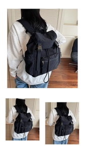 Vue détaillée des boucles et poches zippées du sac à dos noir en nylon texturé