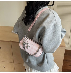 Détail du sac bandoulière en toile à carreaux roses avec chaîne et charm chien