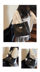 Detail of black tote bag featuring ruched texture and a white butterfly charm accessory