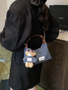 Sac seau en denim rétro avec bandoulière en cuir et accessoire charme ours en peluche