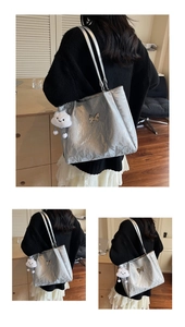Detail of silver metallic tote bag with butterfly ornament and plush cloud charm