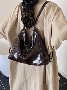 Deep burgundy glossy faux leather multi-way tote bag with silver chain and heart charm detail