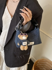 Sac seau en denim bleu avec poignée en cuir et breloque ours dans un style tendance