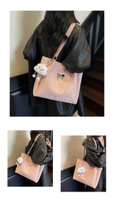 Pink large tote bag detail showing a silver butterfly emblem and fluffy cloud charm accessory