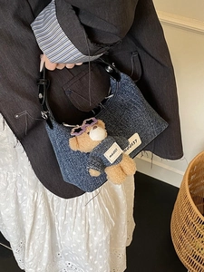 Sac seau vintage en denim bleu avec breloque ours en peluche et bandoulière cuir