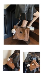Macro detail of brown tote bag with butterfly metal hardware and white plush charm