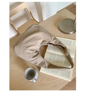 Detail of a khaki canvas tote bag with large capacity in a minimalist lifestyle setting