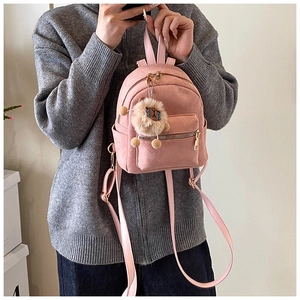 Pink mini faux suede backpack featuring golden zippers and a cute plush lion charm