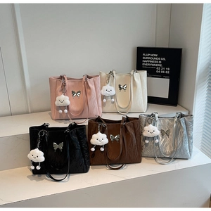 Detailed view of five colorful tote bags with butterfly charms and fluffy cloud pendants