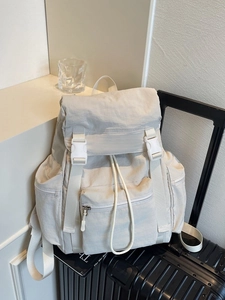 Large beige nylon backpack with buckle closure on luggage for casual travel use