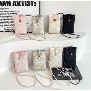 Detailed close-up of jacquard silk crossbody phone bags with Chinese mountain motifs