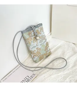 Detail of light blue Chinese style phone bag with gold embroidery and drawstring