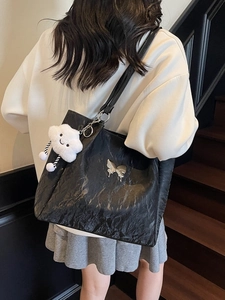Large black crinkle tote bag with silver butterfly emblem and white cloud charm for women